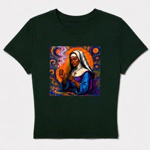 A dark forest green short-sleeve crop top t-shirt featuring a colorful graphic print of a religious figure (Our Lady of Guadalupe) on the chest, displayed against a light gray background.